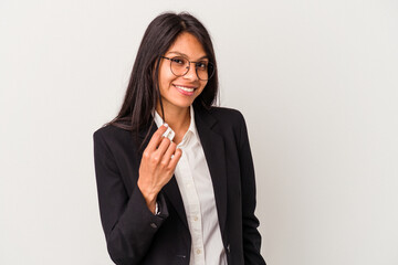 Young business latin woman isolated on white background pointing with finger at you as if inviting come closer.