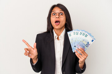 Young business latin woman holding bills isolated on white background pointing to the side