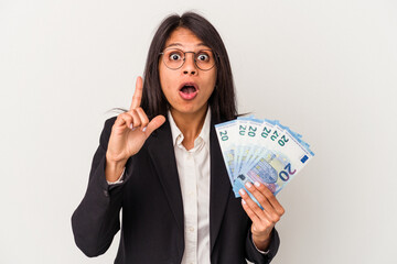 Young business latin woman holding bills isolated on white background having an idea, inspiration concept.