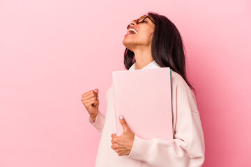 Young student latin woman isolated on pink background raising fist after a victory, winner concept.