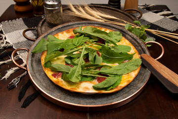 Brazilian pizza with sun-dried tomatoes, arugula and mozzarella