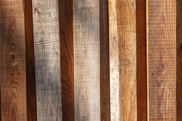 A background wall, made of vertical, brown wooden planks. Copy space. 