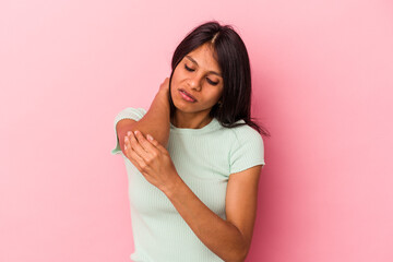 Young latin woman isolated on pink background massaging elbow, suffering after a bad movement.
