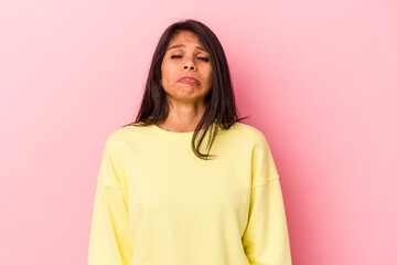 Young latin woman isolated on pink background sad, serious face, feeling miserable and displeased.