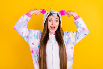 Naklejka na ściany i meble Photo portrait female teenager funny pajama keeping ears laughing happy isolated vibrant yellow background