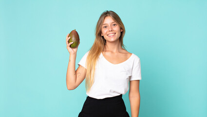 pretty young blonde woman holding a mango