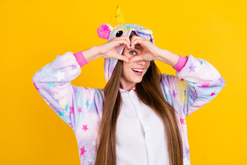 Photo portrait female teenager funny pajama looking showing heart sign fingers isolated vibrant yellow background
