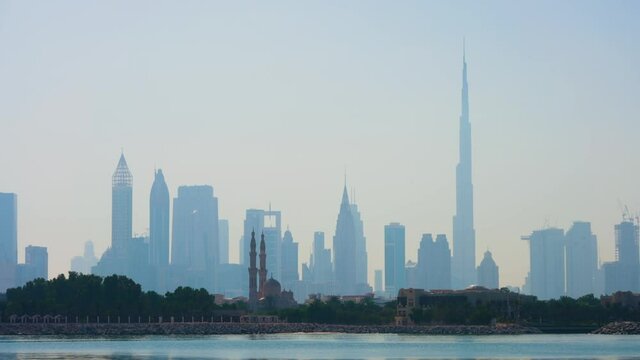 view of skyscrapers and burj khalifa against the background of the canal in the haze