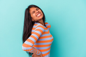 Young latin woman isolated on blue background suffering a back pain.