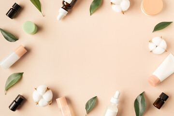 Beautiful spa composition of natural cosmetics mockup bottles with cotton flowers and green leaves on pastel background. Top view. Flat lay style. Copy space.