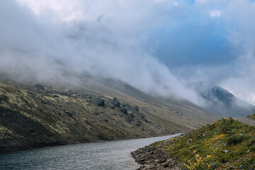 Low cloudiness over a mountain lake in polar autumn. Mountain landscape in Kola Peninsula, Arctic