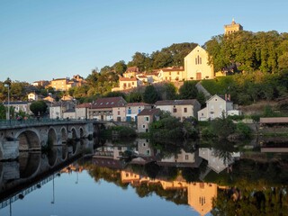 Fototapeta na wymiar beautiful reflections of old French houses and wash house in the river at L'isle Jourdain France