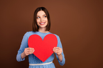 Photo of flirty short hairdo millennial lady hold heart wear blue dress isolated on brown color background