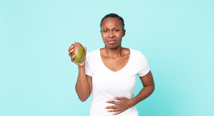 black african american adult woman holding a mango fruit