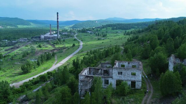 abandoned buildings of the old mine behind the village and a view of the stokehouse with chimneys. a beautiful place in nature in the village. Tuimsky failure in Khakassia. Tuim, Russia. depressing