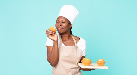 black african american adult chef woman holding a muffins tray