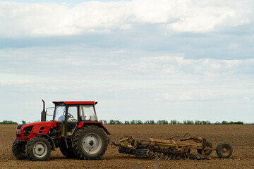 Obraz premium small red farm tractor on the field