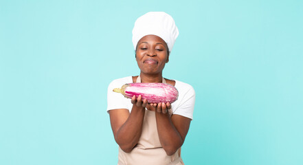 black african american adult chef woman holding an eggplant