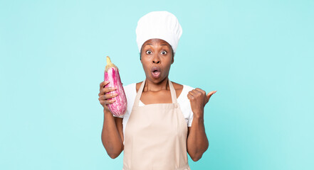 black african american adult chef woman holding an eggplant