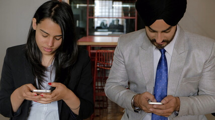 Group of Indian co-workers on their smartphones during the break