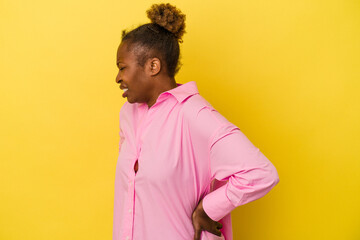 Young african american woman isolated on yellow background suffering a back pain.