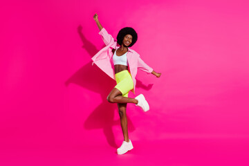 Photo of shiny adorable dark skin lady wear casual shirt dancing smiling isolated pink color background