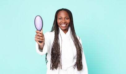 black african american adult woman wearing a bathrobe and holding a hair brush