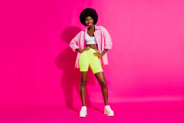 Photo of charming sweet dark skin lady wear casual shirt dancing looking empty space smiling isolated pink color background