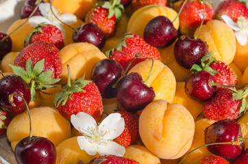 Background from fresh berries and fruits - apricots, strawberries, cherries close-up