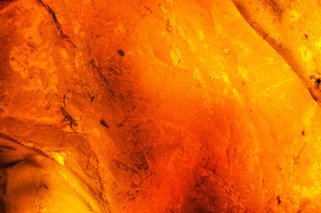 Amber macrophotography abstract background, dark black inclusion, colorful yellow orange and red. unpolished specimen