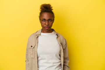 Young african american woman isolated on yellow background sad, serious face, feeling miserable and...