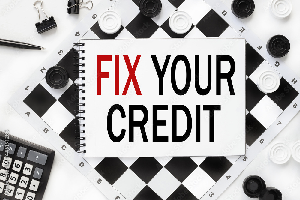 Poster fix your credit. text is written on a notepad on a chessboard