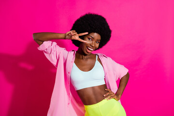 Photo of adorable cute dark skin lady wear casual shirt showing v-sign dancing smiling isolated...