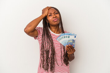 Young african american woman holding banknotes isolated on white background being shocked, she has remembered important meeting.