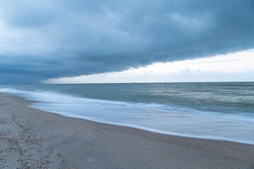 Thunderous gloomy clouds on the sea coast before dawn