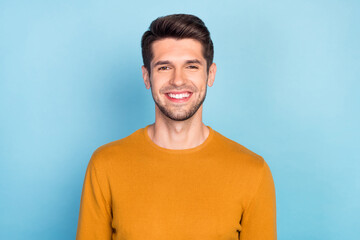 Fototapeta premium Photo of pretty charming young man wear yellow sweater smiling isolated blue color background