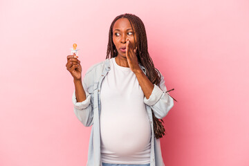 Young african american pregnant woman holding pacifier isolated on pink background is saying a...