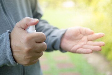 Fototapeta premium Asian man spray wipes his hands with an alcohol-based hand-washing spray as a preventive hygiene measure against coronavirus infection Antibacterial hand sanitizer gel New normal life style Covid-19