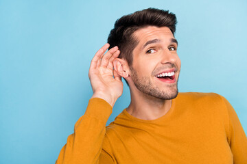 Profile side photo of young cheerful man happy positive smile eavesdrop listen gossip isolated over...