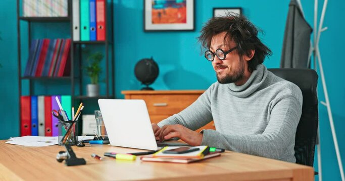 Weird man works in front of computer, writes back emails to customers, taps on laptop keyboard, makes puzzled faces, ponders, happy at work, cabaret performer, meme, nerd with funny glasses