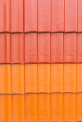 Glossy ceramic colored roof tiles in red and orange