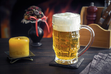 Beer in mug on table in pub against fireplace
