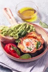 Egg in a hole, fried egg in a roasted acorn squash with tomato and guacamole
