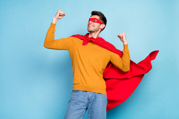 Photo of optimistic brunet young hero guy hands fists wear spectacles cloak sweater isolated on...