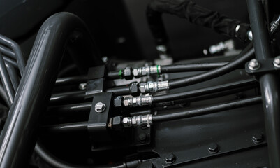 Fototapeta premium Banner with close up view of hydraulic pipes of heavy industry machine. Low key.