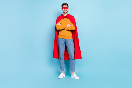 Photo of cute confident young man wear yellow sweater superman outfit smiling hands folded isolated blue color background