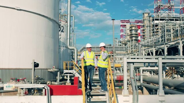 Workers are planning a project on the premises of the oil refinery