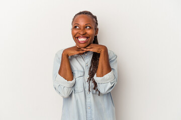 Young african american woman isolated on white background keeps hands under chin, is looking happily aside.