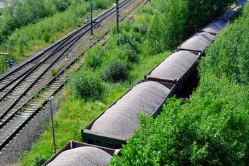 Railway cargo cars loaded with coal. Freight train transporting coal, wood, fuel. Top view.