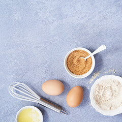 Ingredients, whole grain oat, coconut sugar, vanilla syrup, organic eggs on light blue background. Healthy food recipe photography. Top view. Copy Space.